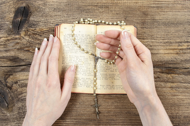 Hands holding the Bible and praying with a rosary - Φωτογραφία, εικόνα
