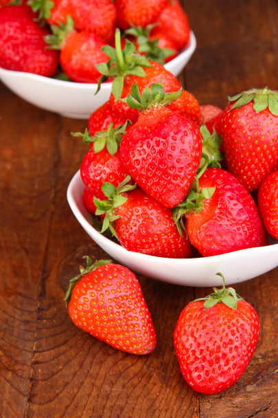 Fresh strawberry in bowl on wooden background - Fotó, kép