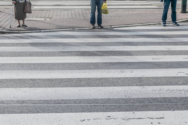 Pedestres esperando para atravessar a estrada, pés correndo através do tráfego zebra caminho a pé
 - Foto, Imagem