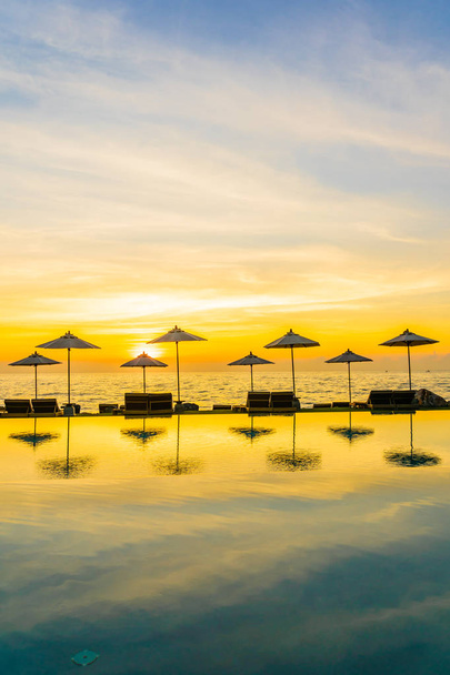 Sonnenschirm und Liegestuhl rund um das Schwimmbad im Resort Hotel für leis - Foto, Bild