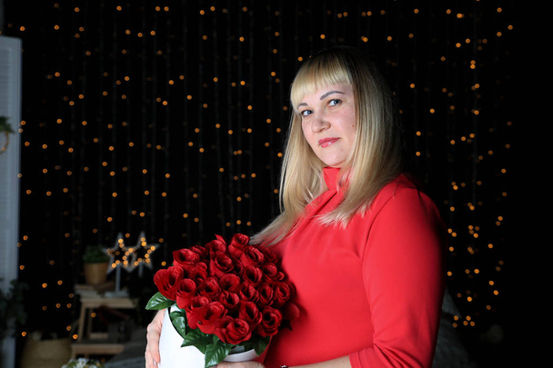 young woman holding red roses at home  - Photo, Image