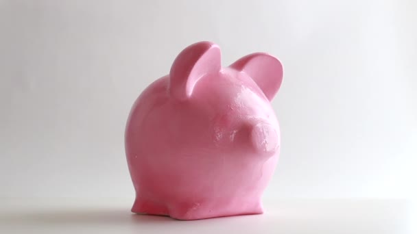 Hand legt einen Dollar ins Sparschwein, das Konzept des Sparens für die Zukunft im Ruhestand - Filmmaterial, Video