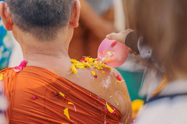 Люди льют воду буддистскому монаху и дают благословение в Таиланде Сонгкран ежегодный фестиваль
 - Фото, изображение