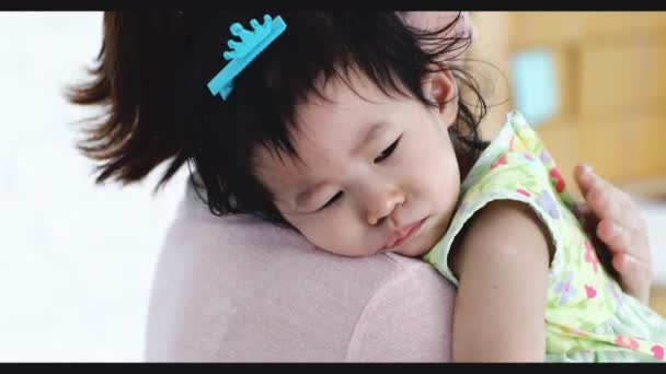 Mladá matka uklidňuje malé plačící miminko doma v ložnici. Detailní záběr na malé dítě pláče, máma ji uklidňuje. - Záběry, video