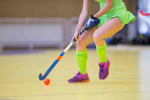 Young hockey player woman with ball in attack playing field hockey game - Photo, Image