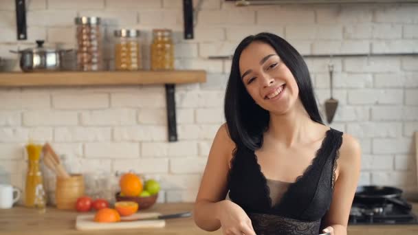 Young attractive woman cooking at the kitchen. - Imágenes, Vídeo