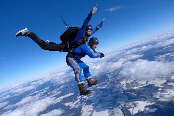 Tandem skydiving. Two guys are having fun in the blue sky. - Photo, Image