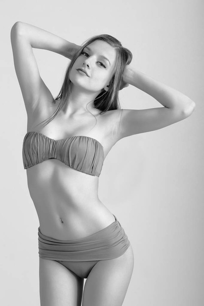 Slim body of young woman in bikini on white . Girl with healthy sporty figure - Fotografie, Obrázek
