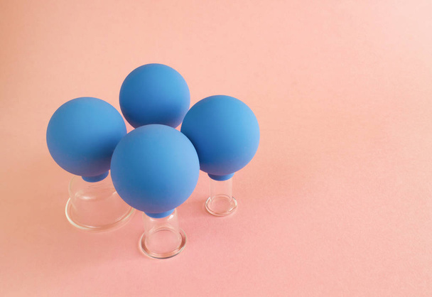 blaue kosmetische Vakuumdosen in verschiedenen Größen aus Glas und Gummi auf rosa Hintergrund - Foto, Bild