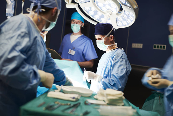 Gruppe umtriebiger Ärzte und ernsthafter Operationen - Foto, Bild