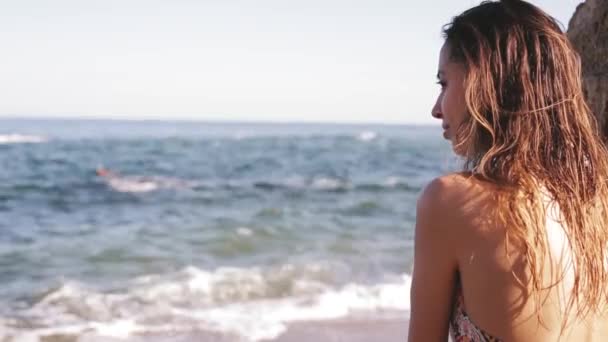 Portret pięknej zdrowej kobiety z Fit Body w modzie sexy bikini. Model stwarzające na tle morza w promieniach słońce ustawienie - Materiał filmowy, wideo