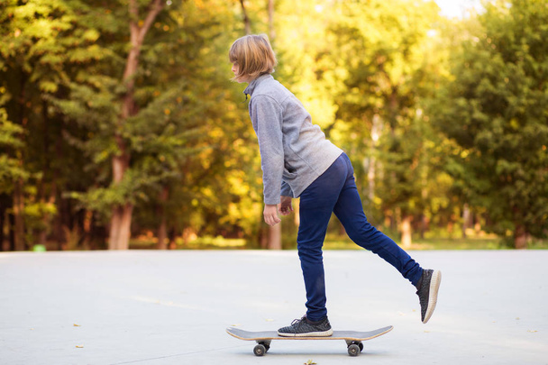 jong sportief meisje rijden op longboard in park. - Foto, afbeelding
