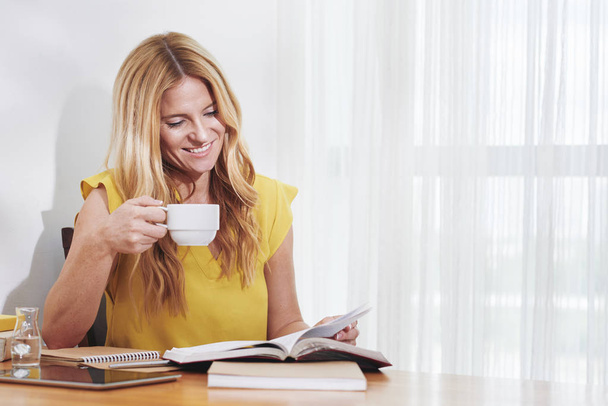 Atraktivní mladá žena konzumní kávu a čte si knihu  - Fotografie, Obrázek