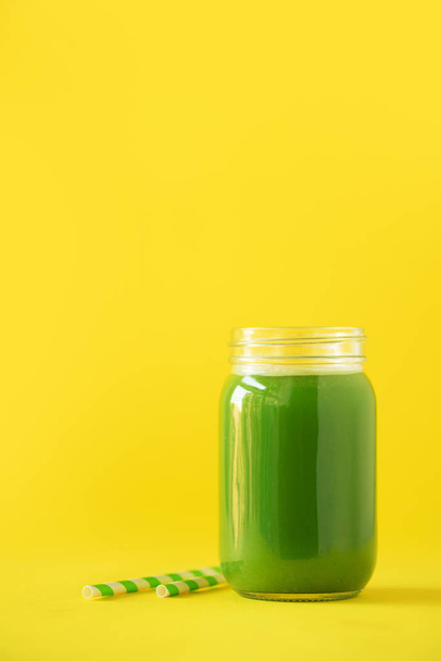 Bottle of green celery smoothie on yellow background. Banner with copy space. Fresh juice for detox. Vegan, alkaline healthy diet concept - Photo, Image