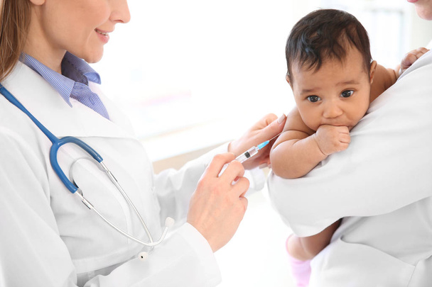 Pediatrician giving little baby an injection in clinic - Foto, Imagen