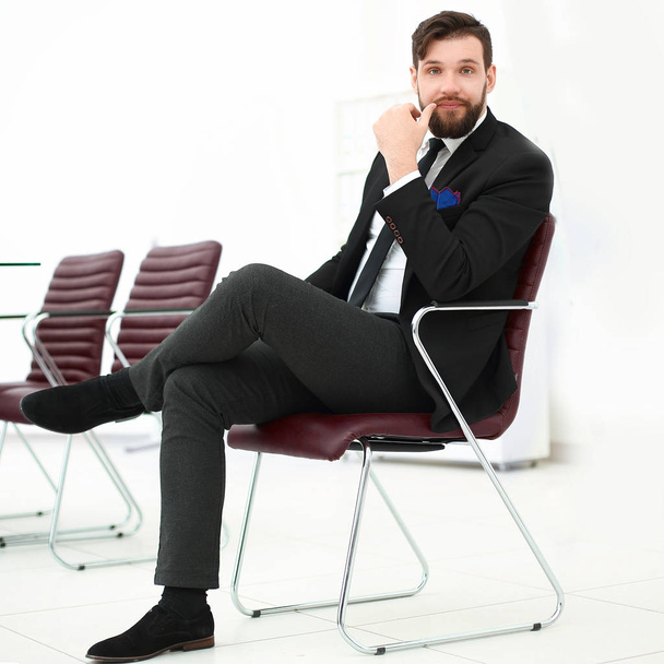 handsome businessman sitting on a chair in a conference room - Photo, image