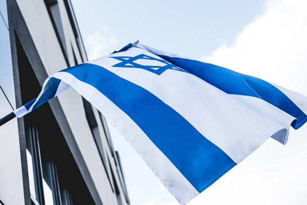 Blick auf israel flag mit david stern in der nähe des gebäudes gegen himmel - Foto, Bild