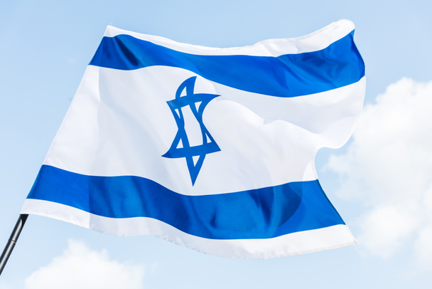 low angle view of national israel flag with star of david against blue sky - 写真・画像