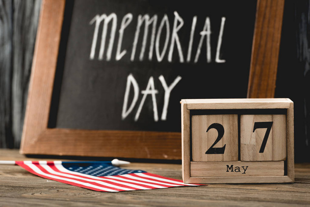 wooden cubes with date near flag of america with stars and stripes and memorial day lettering on chalkboard  - Photo, Image