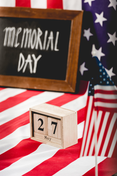 kubussen met datum in de buurt van vlag van Amerika met sterren en strepen en Memorial Day belettering op schoolbord  - Foto, afbeelding