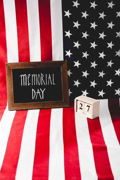 γράμματα ημέρα μνημείου σε μαυροπίνακα κοντά σε ξύλινα κύβους με ημερομηνία και σημαία της Αμερικής  - Φωτογραφία, εικόνα