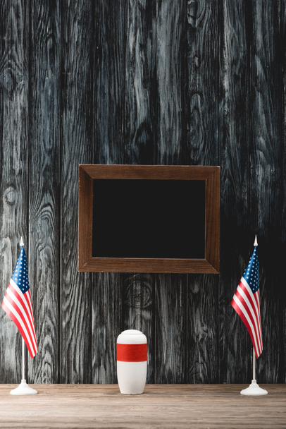 empty black board near funeral urn with ashes and american flags - Photo, Image