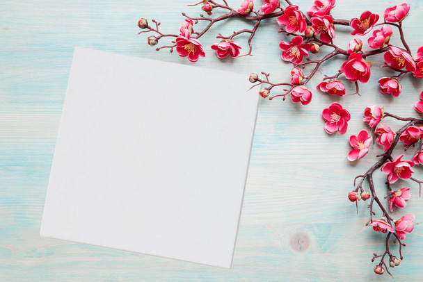 Розовые цветы на синем деревянном фоне и лист бумаги
 - Фото, изображение