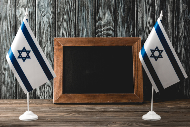 national israel flags with star of david near empty chalkboard - Photo, Image