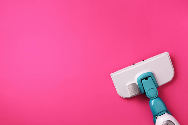 Steam cleaner mop on pink background. Top view, flat lay. Banner with copy space. Cleaning service concept - 写真・画像