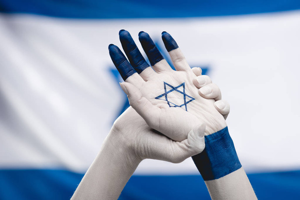 ダビデの星の近くの旗を持つ女性の手のクロップビュー - 写真・画像