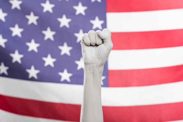 アメリカ国旗近くの拳を白で描いた女性手のクロップドビュー - 写真・画像