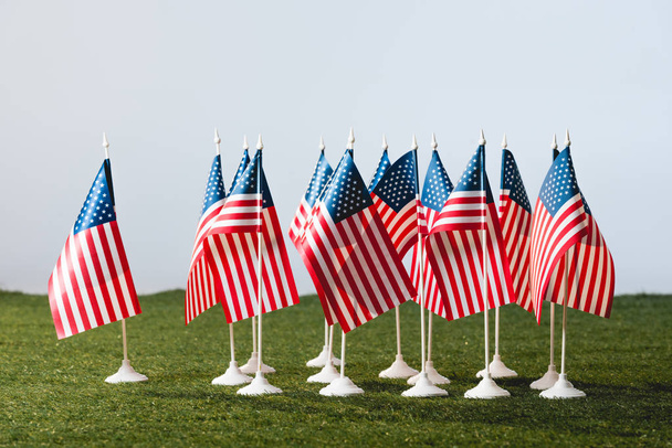 banderas americanas con estrellas y rayas sobre hierba verde aisladas sobre gris
  - Foto, Imagen