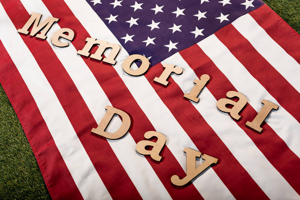 memorial day lettering on american flag with stars and stripes on green grass - Photo, Image