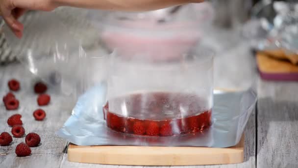 Vrouw banketbakker raspberry cake maken in bakkerij. - Video