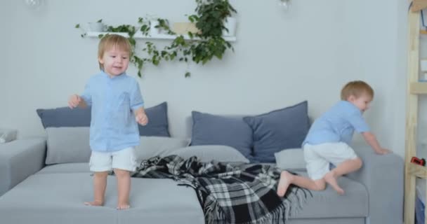 Kaksi pientä poikaa hyppii sohvalla ja pitää hauskaa
 - Materiaali, video
