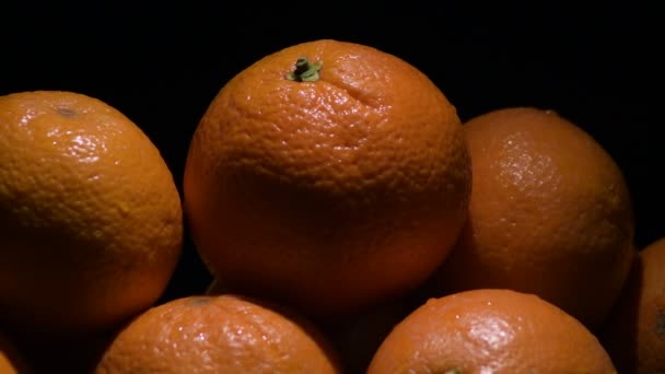 Pomarańcze naturalne owoce mimośrodowo na czarnym tle - Materiał filmowy, wideo