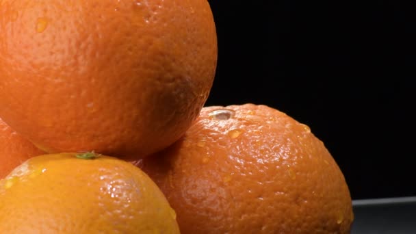 Verse sinaasappelen fruit gyrating op zwarte achtergrond - Video