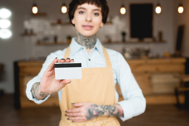 επιλεκτική εστίαση της σερβιτόρα κρατώντας πιστωτική κάρτα και να βλέπουν τα φωτογραφικών μηχανών - Φωτογραφία, εικόνα
