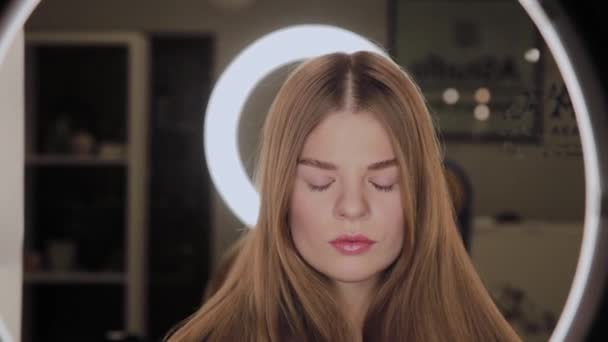 Portrait of a girl with a reflection of the annular LED light in the eyes. - Video
