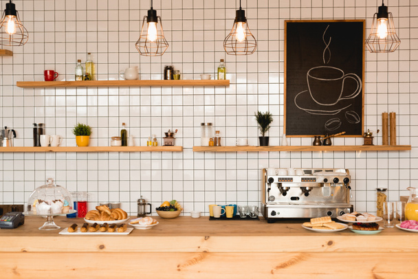 интерьер кафе с деревянным барной стойкой, полками и плиточной стеной
  - Фото, изображение