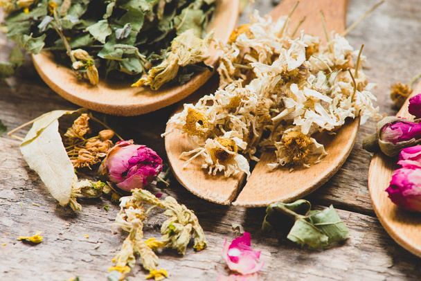 Aromatic flowers tea in spoons on rustic wooden background - Fotografie, Obrázek
