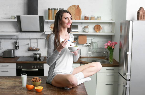 Beautiful woman having breakfast in kitchen at home - Fotografie, Obrázek