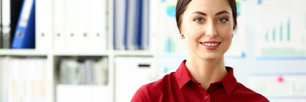 schöne lächelnde Mädchen in roter Bluse am Arbeitsplatz Blick in die Kamera - Foto, Bild