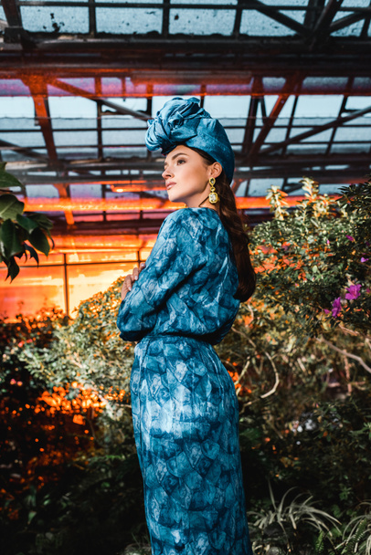 Gyönyörű fiatal nő, a kék ruhában, az üvegházban turbán - Fotó, kép