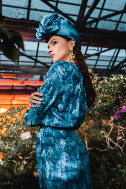 hinreißende junge Frau in blauem Kleid mit Turban in Orangerie - Foto, Bild
