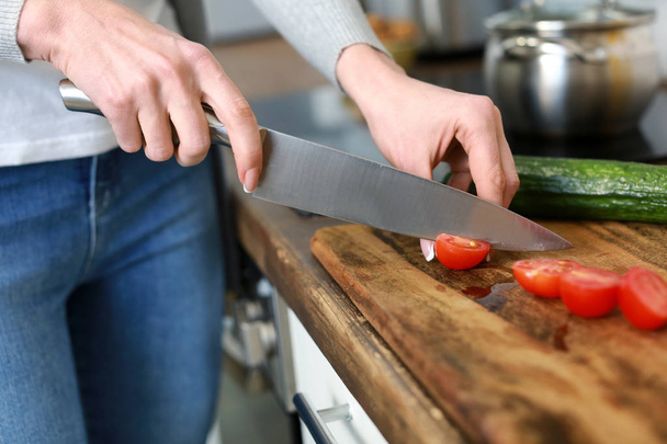 Mooie vrouw snijden groenten in de keuken thuis, close-up - Foto, afbeelding