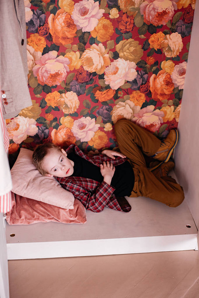 little boy lying in wardrobe at home  - Foto, Bild