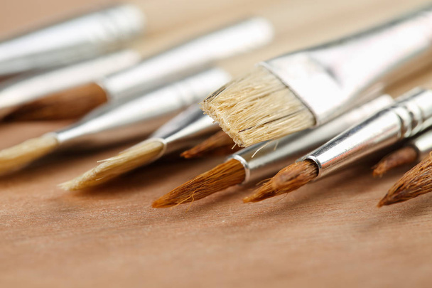 Extreme close-up van een set art verf penselen op een houten palet. Ondiepe scherptediepte - Foto, afbeelding