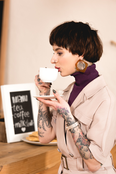 beautiful businesswoman drinking coffee at bar counter in coffee shop  - Photo, Image