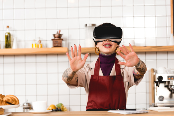 barista-virtuális valóság fejhallgató áll közel inspirációk a cafteria mosolyogva - Fotó, kép